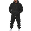 Person wearing a black tracksuit with yellow accents on a white background