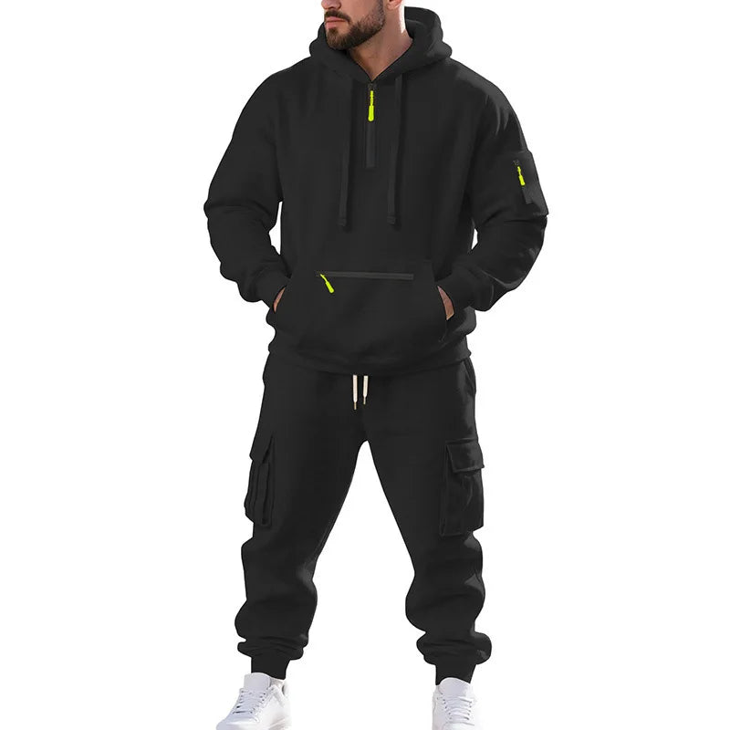 Person wearing a black tracksuit with yellow accents on a white background