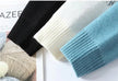 Three knitted sleeves in black, white, and blue on a magazine background.
