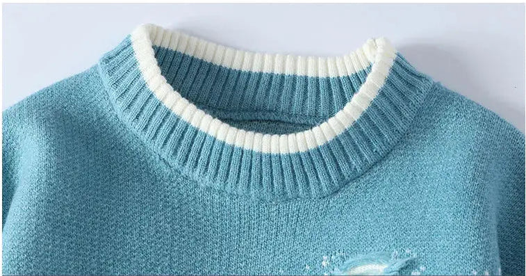 Close-up of a blue sweater with white trim on a light gray background