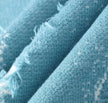 Close-up of blue fabric with visible texture and Chinese text on a light blue background