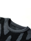 Close-up of a dark gray sweater with a pattern on a white background