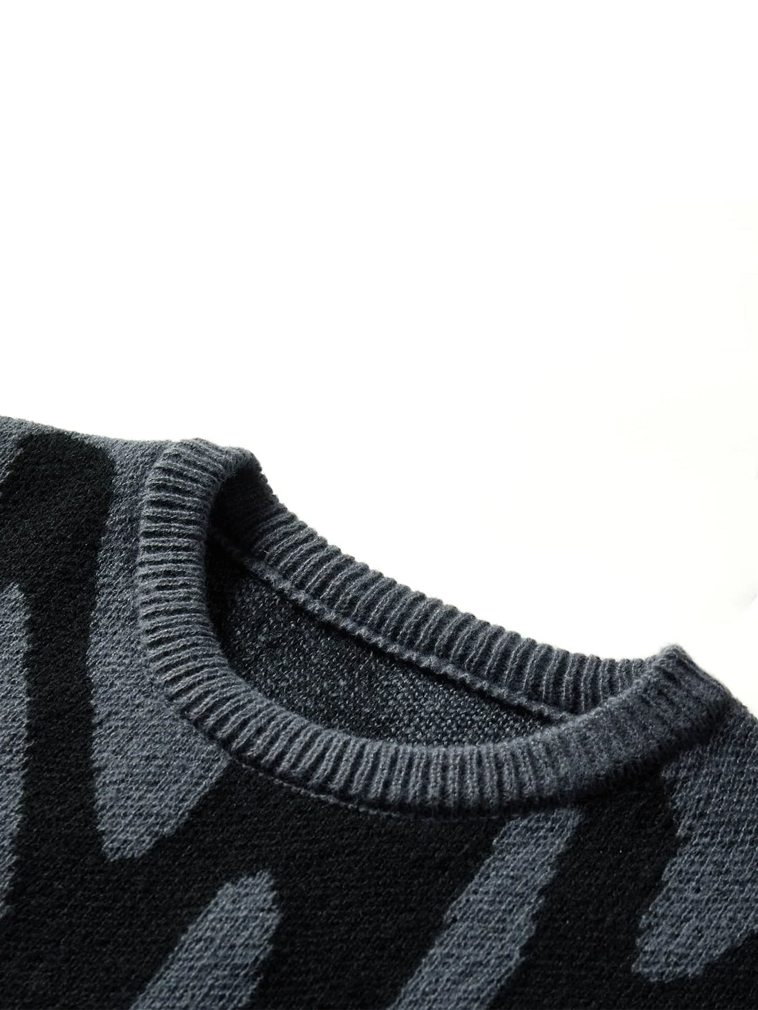 Close-up of a dark gray sweater with a pattern on a white background