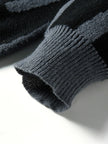 Close-up of a dark gray knitted sweater sleeve on a light background