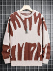 Brown and white patterned sweater on a hanger against a grid background