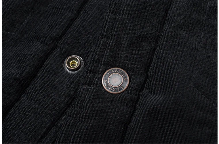 Close-up of black corduroy fabric with two buttons on a white background