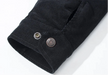 Close-up of a black corduroy shirt with buttons on a white background