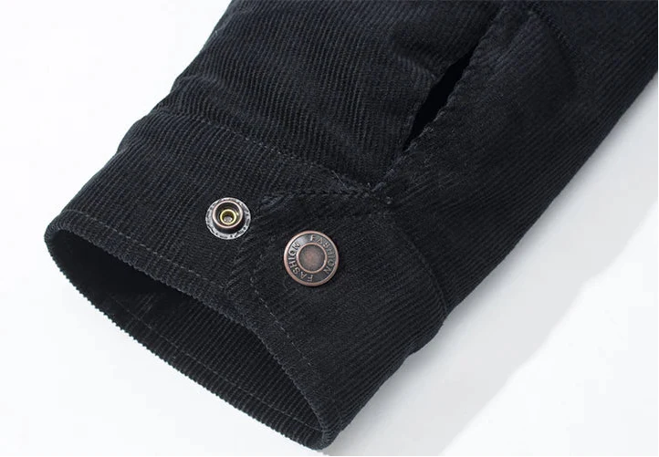 Close-up of a black corduroy shirt with buttons on a white background