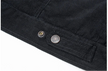 Close-up of black corduroy fabric with buttons on a white background