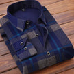 Folded blue and gray plaid shirt on a wooden surface