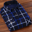 Folded blue and white plaid shirt on a wooden surface