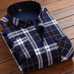 Folded navy and white plaid shirt on a wooden surface