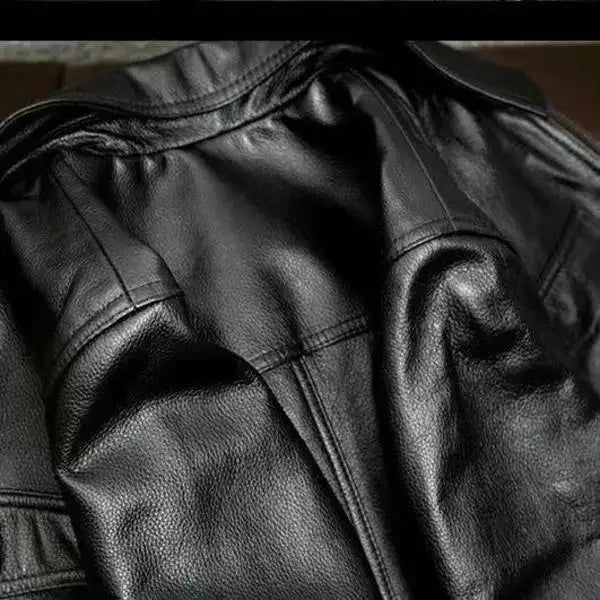 Close-up of a black leather jacket with visible texture and stitching.