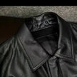 Close-up of a black leather jacket with a textured surface.