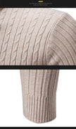 Close-up of a beige cable knit sweater sleeve with a black bar in the middle.