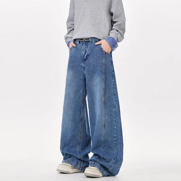 Person wearing wide-leg blue jeans and a gray sweater on a white background