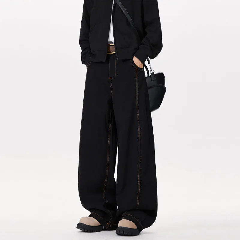 Person wearing a black suit with wide-leg pants on a white background