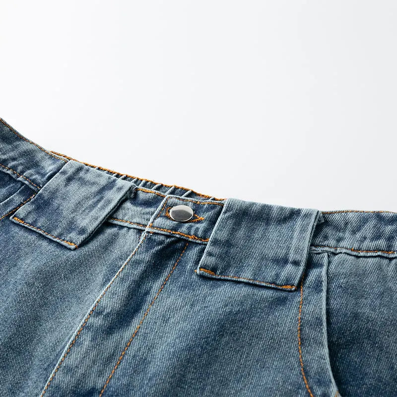 Close-up of blue denim fabric with stitching details on a light gray background