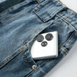 Smartphone with a unique camera design in a pocket of blue jeans