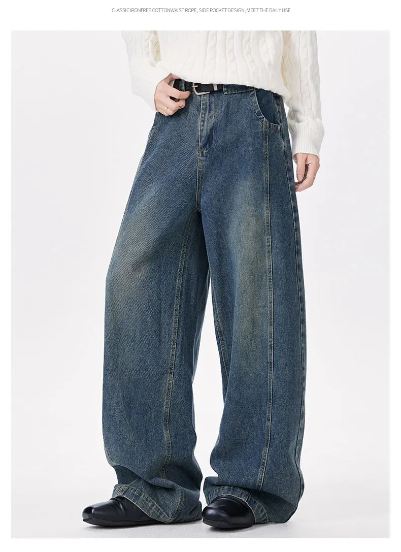 Person wearing wide-leg blue jeans on a white background