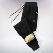 Black fleece pants with beige patches on a light gray background