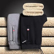 Gray and black backpacks with a beige towel on a textured surface