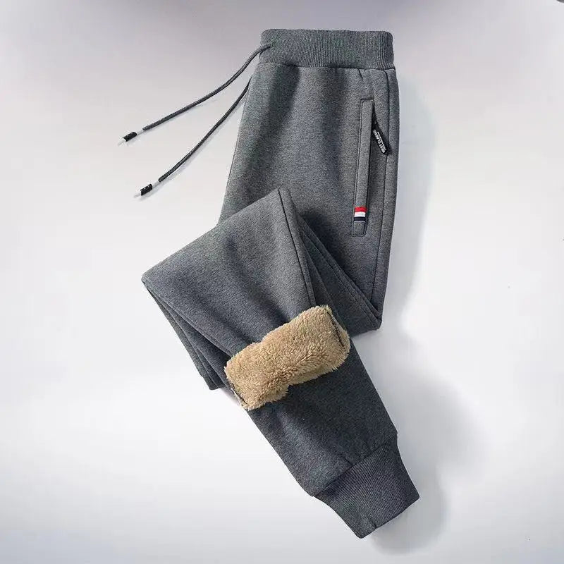 Gray sweatpants with brown patch on a light gray background