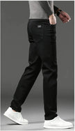 Person wearing black pants and white shoes on a gray background
