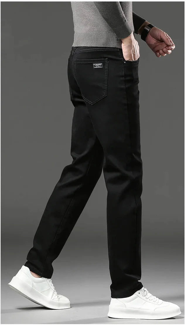 Person wearing black pants and white shoes on a gray background