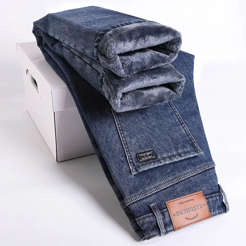 Folded blue jeans with a brand label on a white background