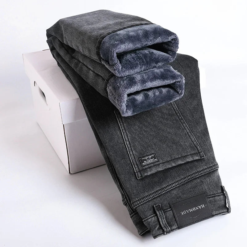 Folded gray jeans with a white box on a light gray background