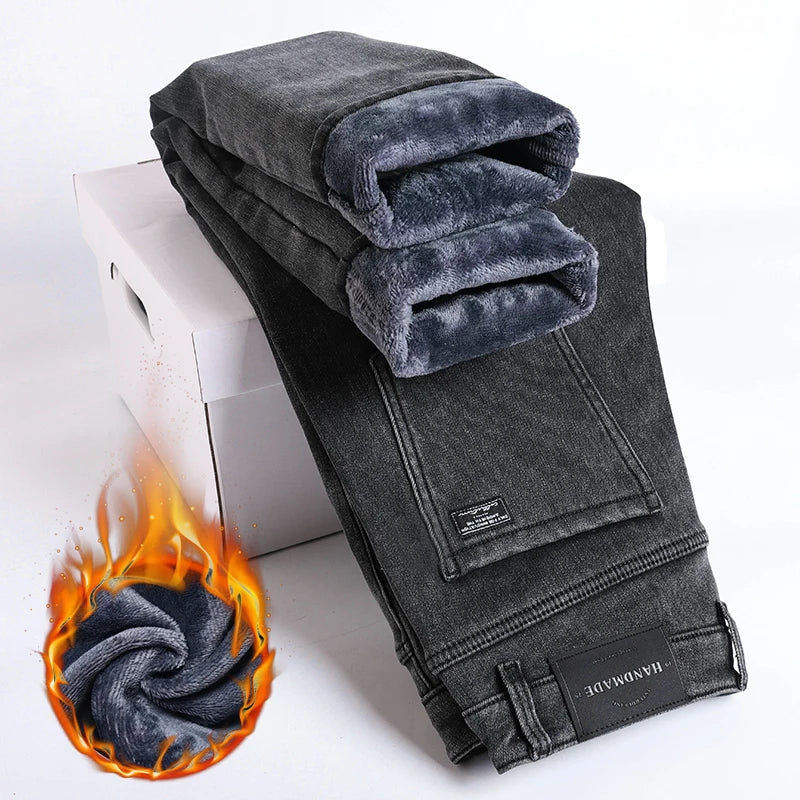 Folded gray jeans with a flame graphic on a white background