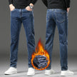 Person wearing blue jeans with a fiery graphic at the bottom on a gray background
