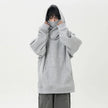 Person wearing a gray oversized hoodie on a white background
