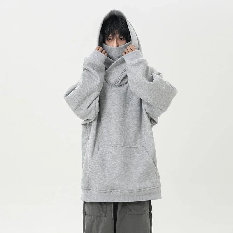Person wearing a gray oversized hoodie on a white background
