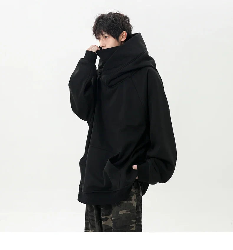 Person wearing a black oversized hoodie on a white background