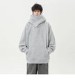 Person wearing a gray oversized hoodie on a white background