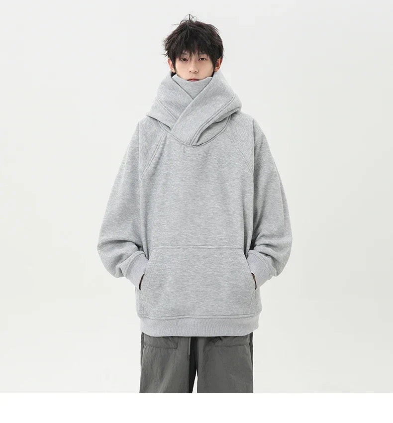 Person wearing a gray oversized hoodie on a white background