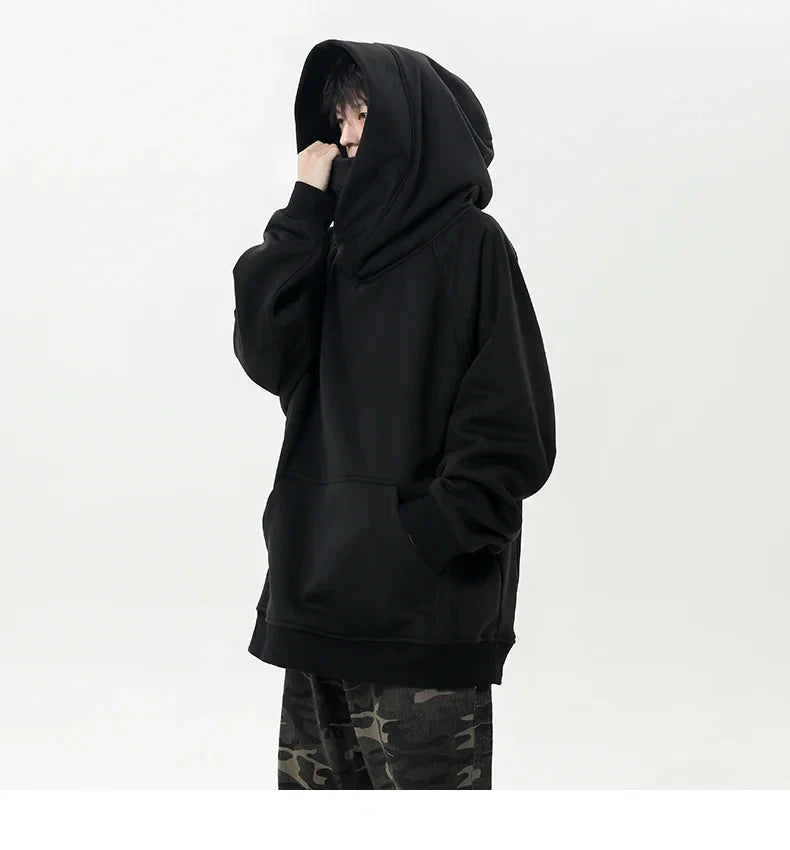 Person wearing a black hoodie with camouflage pants on a white background