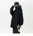 Person wearing a black hoodie holding headphones on a white background