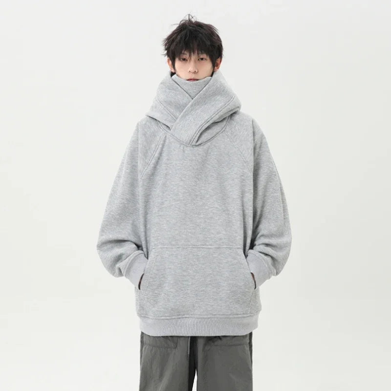 Person wearing a gray oversized hoodie on a white background