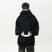 Person wearing a black oversized hoodie on a white background