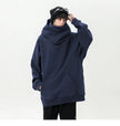 Person wearing a navy blue hoodie and black pants on a white background