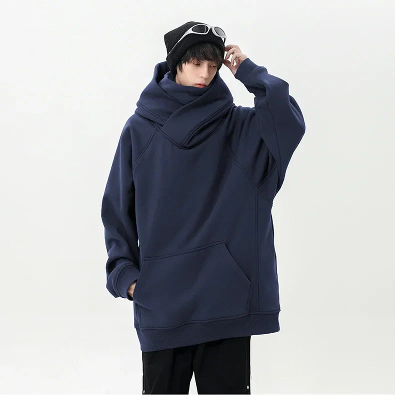 Person wearing a navy blue hoodie and black pants on a white background