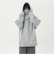 Person wearing a gray oversized hoodie on a white background