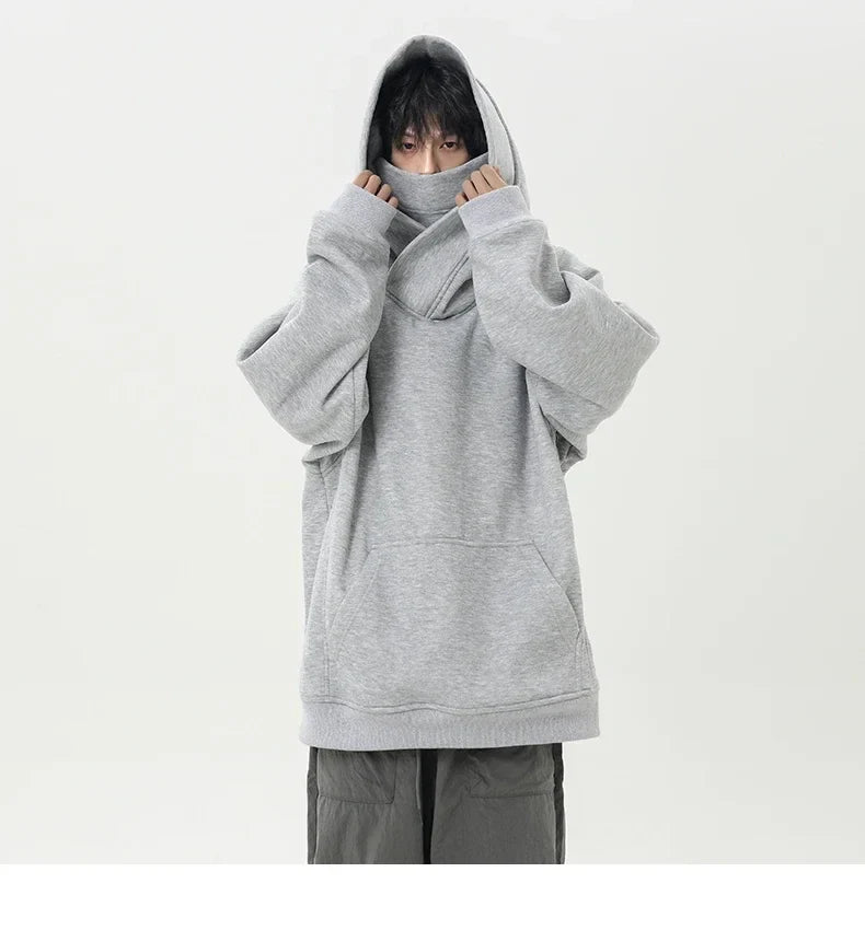 Person wearing a gray oversized hoodie on a white background