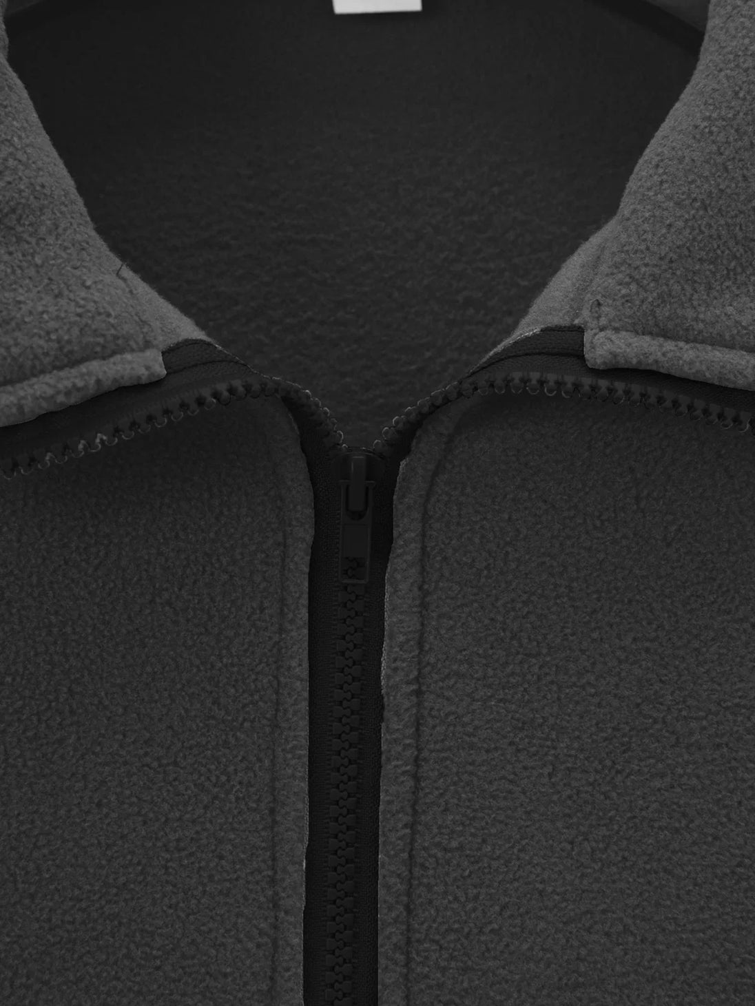 Close-up of a gray fleece jacket with a zipper