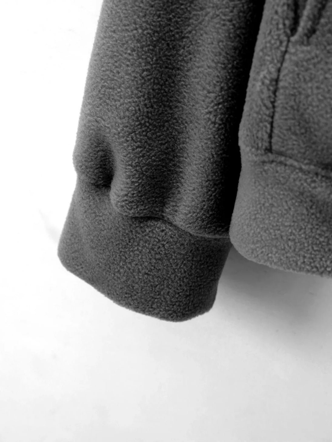 Close-up of dark gray fleece fabric on a white background