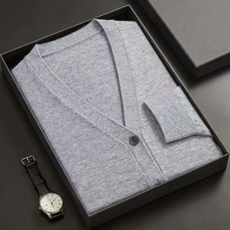 Gray cardigan in a black box with a watch on a dark surface