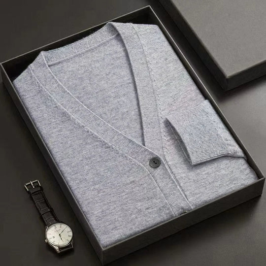Gray cardigan in a black box with a watch on a dark surface
